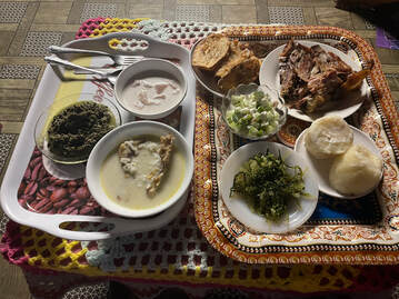 Left tray: pulasami, oka, fish is coconut milk; right tray: chicken, pork, yams, seaweed, cucumber-tuna, and bread?