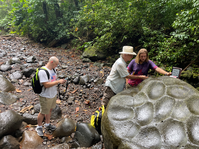 Centre for Samoan Studies archaeologist Gregory Jackmond teaching University of Alabama student research assistants how to measure and records dimensions of all the grinding surfaces on this large foaga (grinding stone).