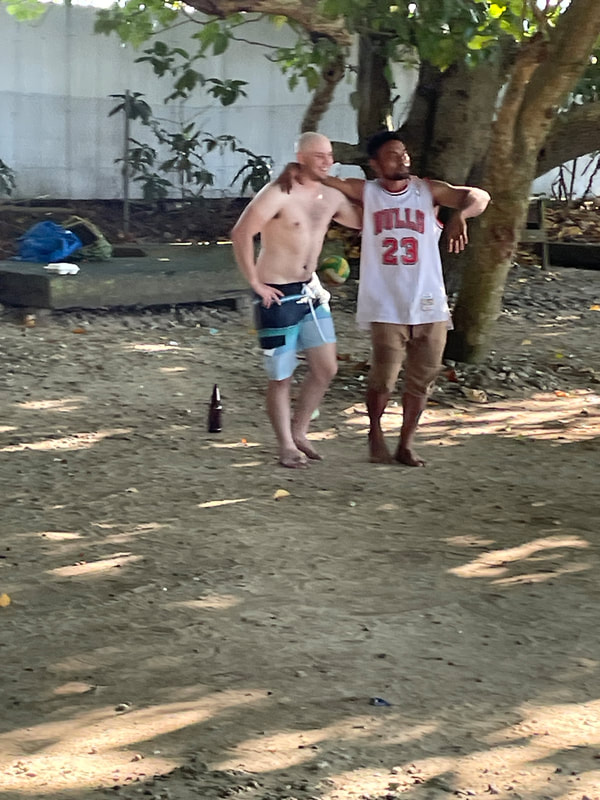 Grant dancing with a happy drunk at the beach.
